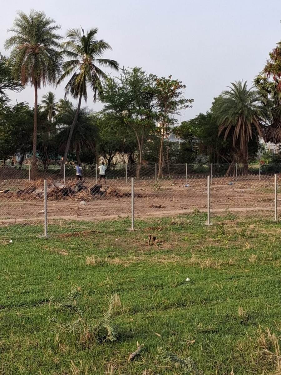 Worker completing the chain-link fence installation