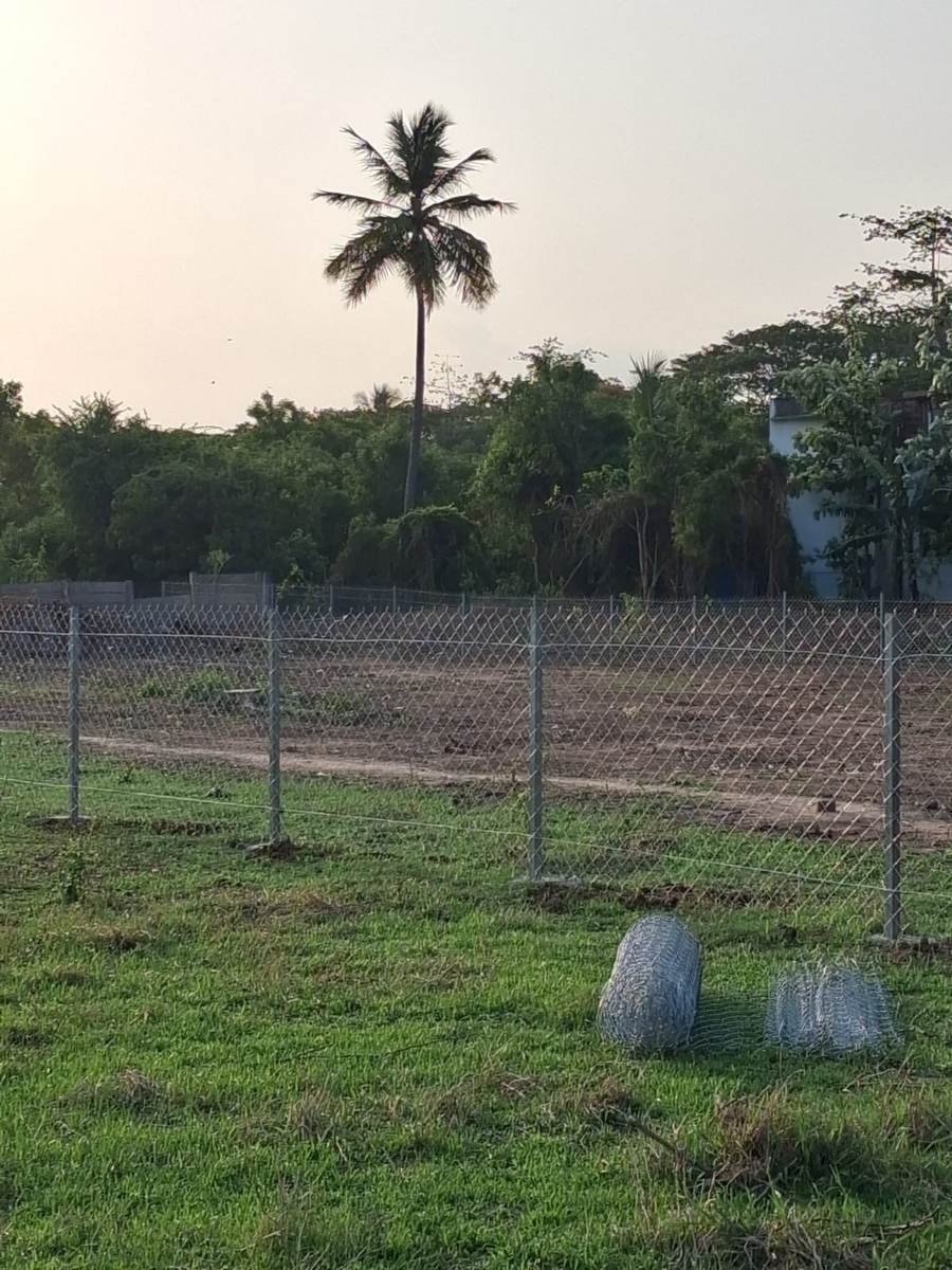 Completed chain-link fencing around the SWM site, with wire coils on the ground